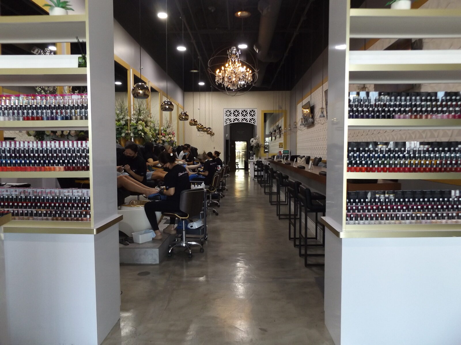 Inside Blossom's Nails Boutique looking down the salon aisle to the crystal chandelier